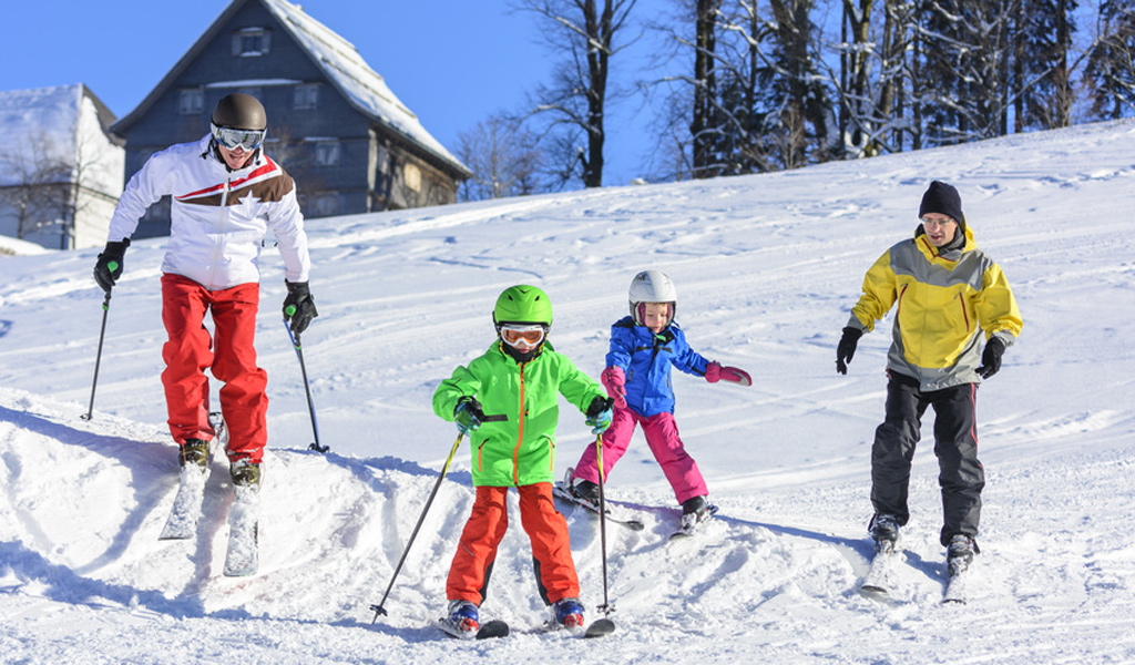 Familie übt auf der Skipiste das Skifahren